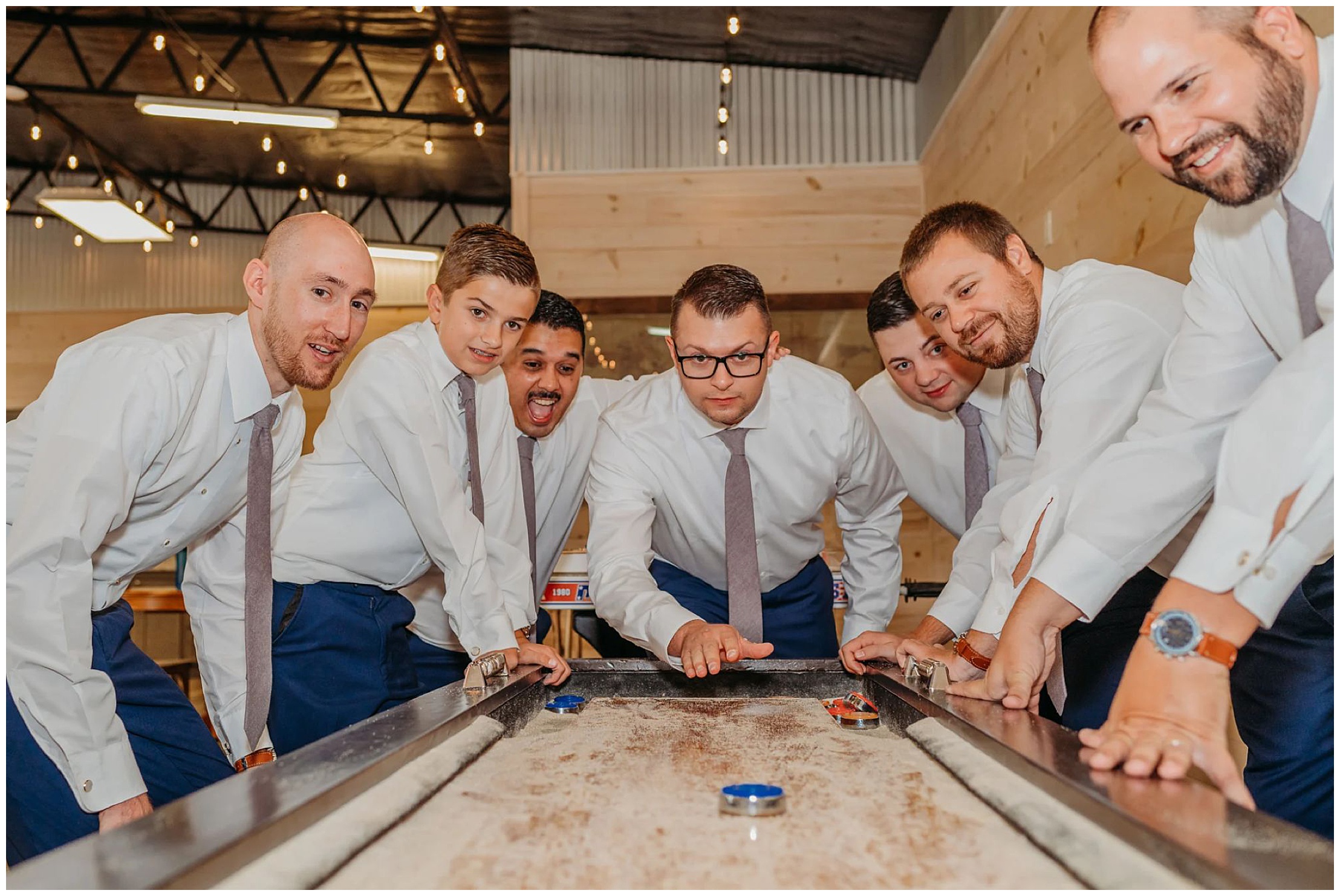 groom and groomsmen playing games at The Bowtie Club in Howe Farms
