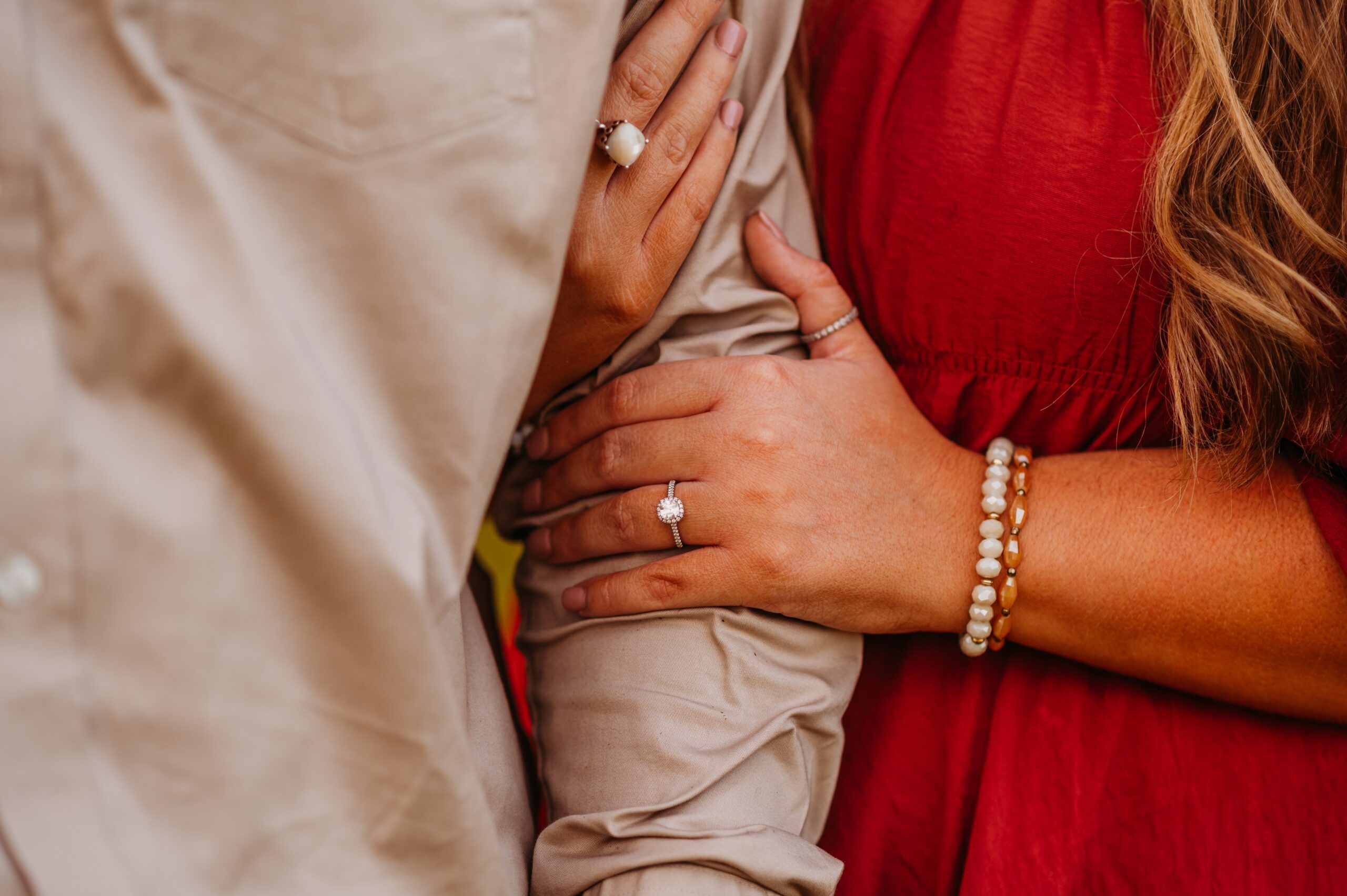 engagement ring picture as a woman hugs a man's arm
