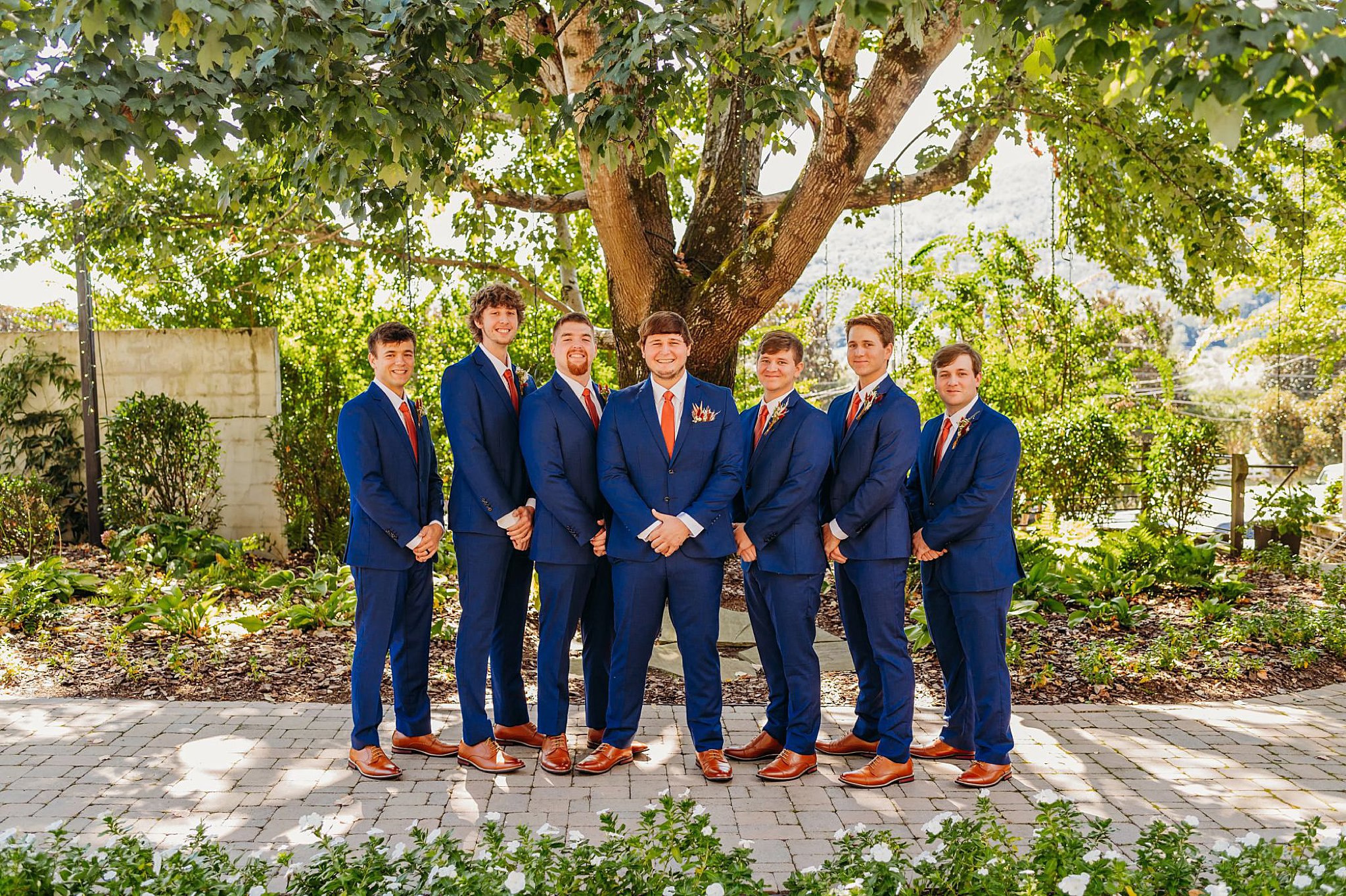 photo of groom and groomsmen in navy suits with maroon ties. standing on a path at The Venue Chattanooga