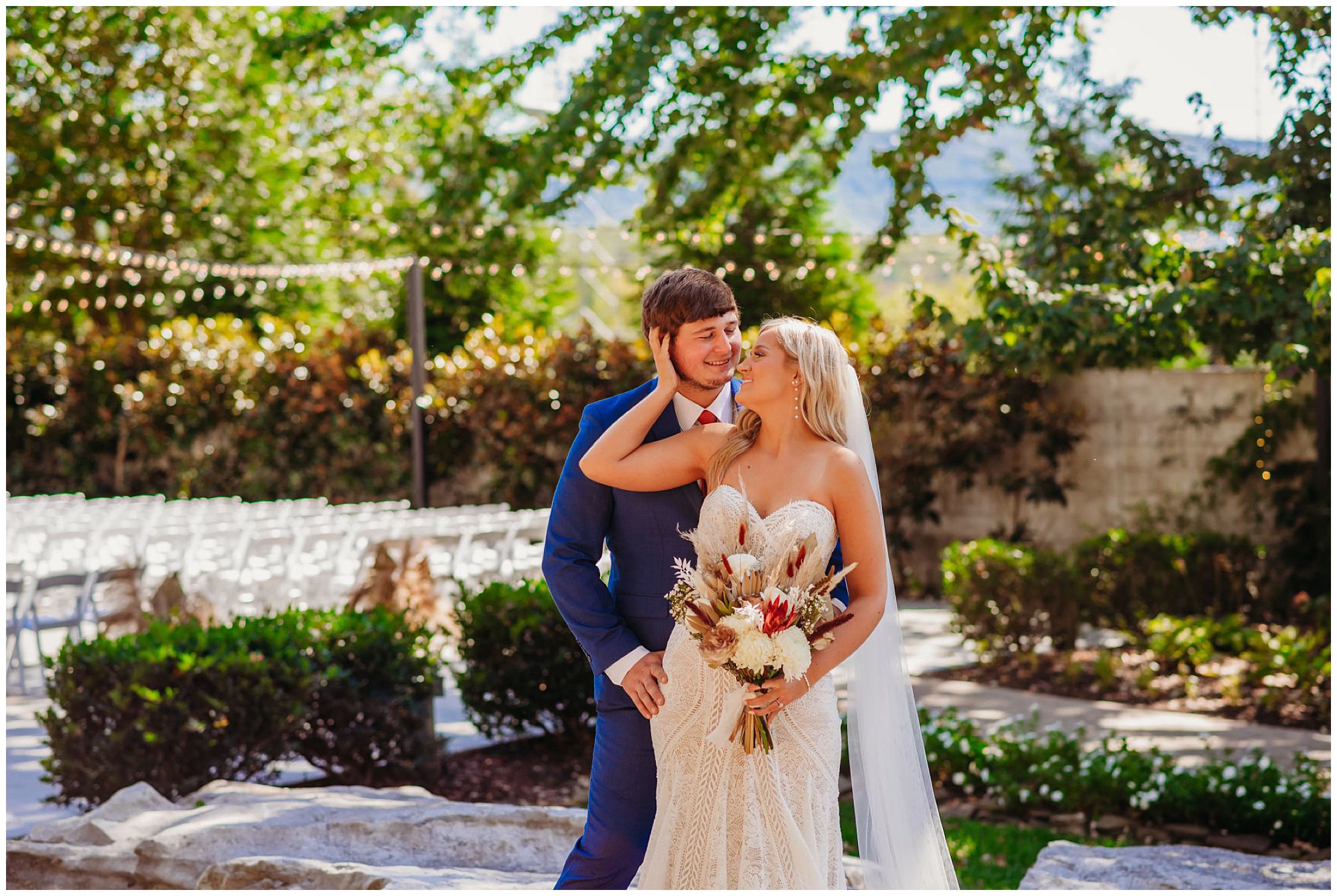 photo of bride caressing groom's face and he hugs her hips