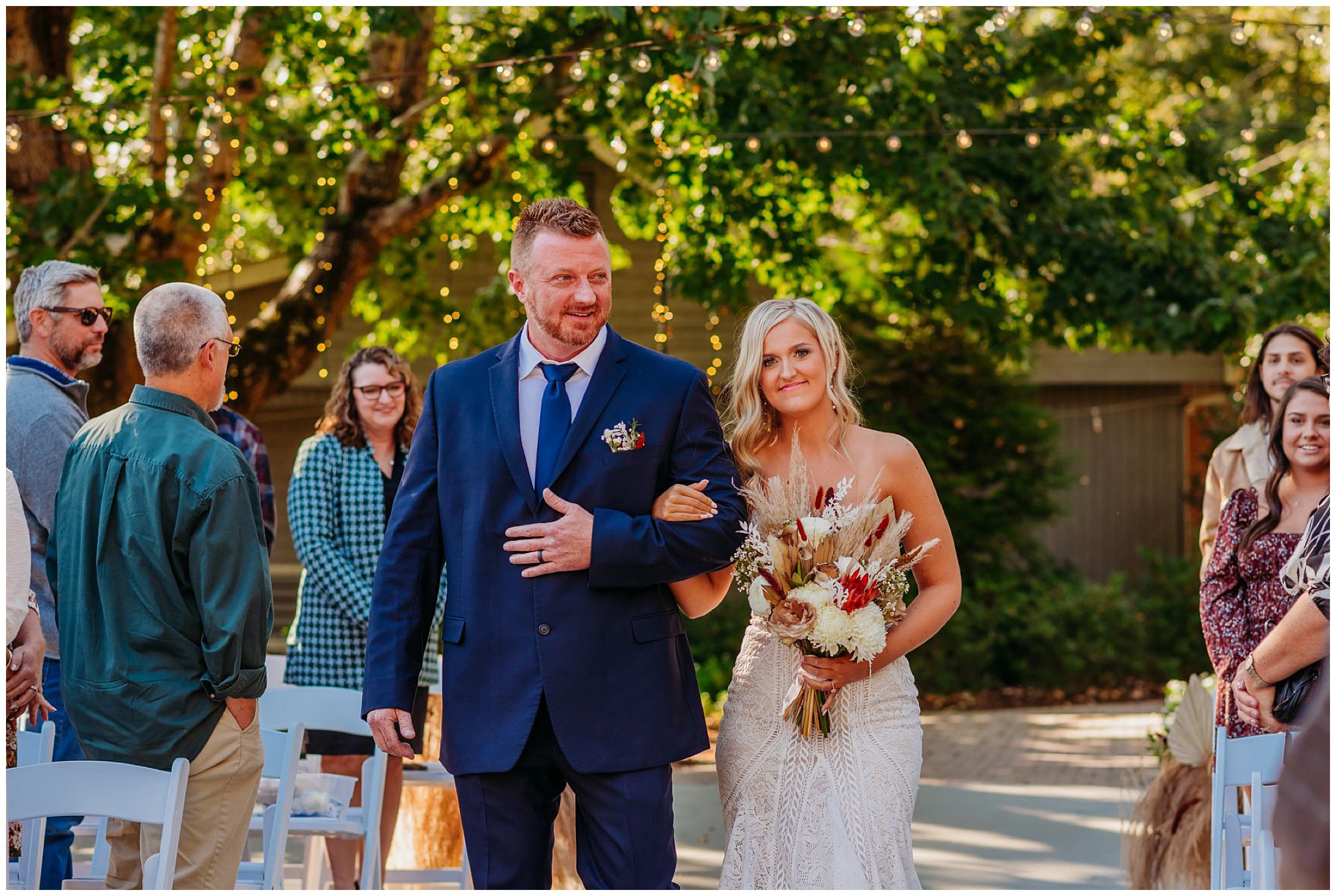 bride and her dad walking down the aisle at a wedding ceremony with smiling guests