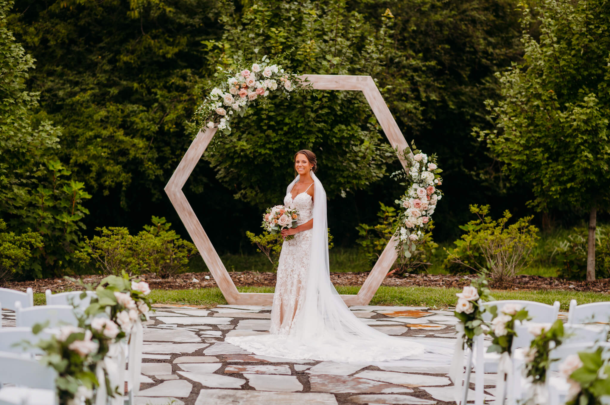 photo of a bride on a stone path with arch in the background